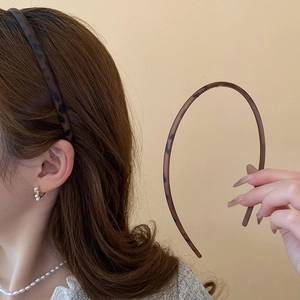 Detailed view of the leopard print headband showing anti-slip inner teeth and slim design