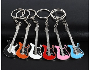 Detailed view of six colorful metal guitar keychains in black, orange, white, red, pink, and blue