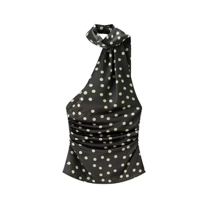 Detailansicht der glatten Satin-Textur und des Retro-Punktmusters auf dem Halter-Top