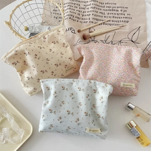 Detailed flat lay of floral corduroy cosmetic bags with Sorakka label on white background