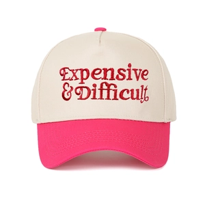 Macro detail of red 3D embroidery text on two-tone beige and pink baseball cap