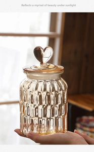 Detail of amber glass storage jar with heart-shaped handle and vertical striped texture