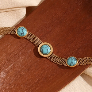 Close-up of gold mesh chain bracelet with blue turquoise stones on wooden background