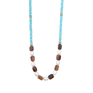 Macro detail of natural tiger eye, turquoise beads, and pearls on a handmade necklace