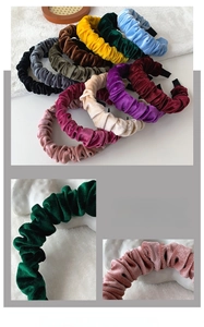 Detail showing colorful ruched velvet headbands with soft pleated texture and adjustable fit