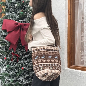 Detail of plush winter tote bag with Nordic reindeer pattern shown on model