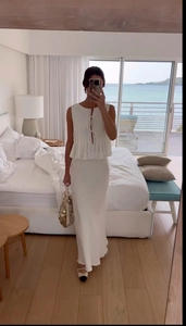 Detail of white pleated sleeveless crop top and high waist maxi skirt beach set