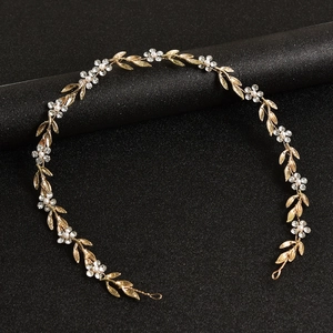 Détail du bandeau de mariée avec feuilles dorées et fleurs en strass scintillants