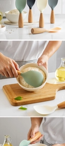 Detailed view of standing silicone rice spoons with wooden handles in various colors