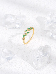Detail of adjustable gold leaf ring with green marquise stones and clear crystals