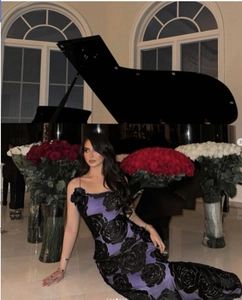 Detailed view of dark purple evening dress featuring textured black rose floral patterns