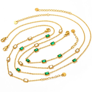 Detail of gold-plated stainless steel bracelets with green and white zircon gemstones