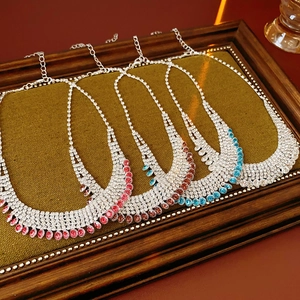 Close-up of multi-row rhinestone fringe necklaces in pink, blue, and champagne