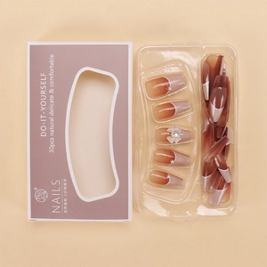 Macro detail of 30pcs brown gradient press-on nails with bow and rhinestone accents