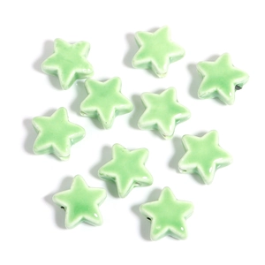 Flat lay macro of light green star ceramic beads with a smooth glazed finish for DIY