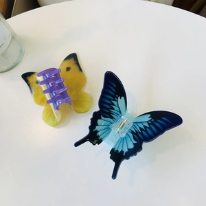 Detail showing colorful acrylic butterfly hair claws with gradient wings and glossy finish