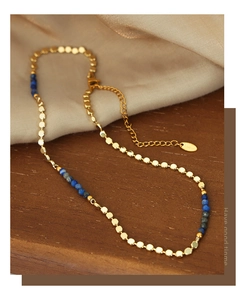 Detailed shot of titanium steel necklace with blue natural stones and gold beads
