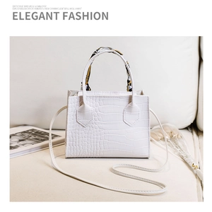Détail du sac blanc motif crocodile avec foulard en soie décoratif sur la poignée