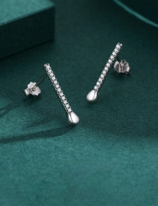 Macro shot of silver micro-paved bar stud earrings with elegant teardrop shape details