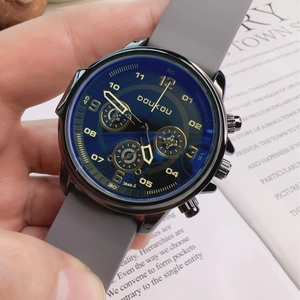 Detail of blue chronograph dial with gold hands and gray silicone strap on men's watch