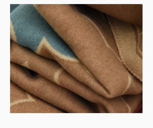 Macro detail of soft brown wool fabric texture with blue pattern for kids scarf