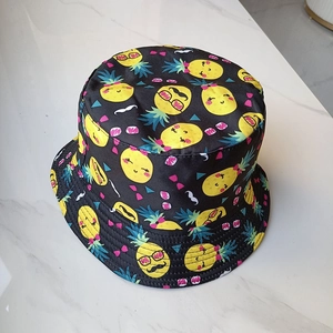 Détail d'un chapeau bob pliable avec des motifs de mangues mignons sur tissu noir