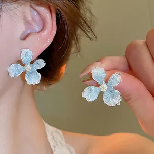 Elegant blue floral stud earrings with gradient petals and shimmering crystal centers