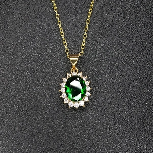 Detailed close-up of emerald green pendant necklace with oval crystal and gold chain