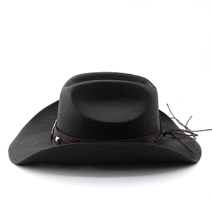 Détail d'un chapeau de cowboy en paille noire avec ruban en cuir et rivets en métal