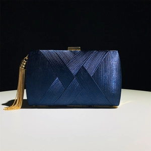 Navy blue satin evening clutch bag with gold tassel and cross-texture on a black background