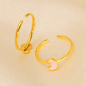 Gold adjustable ring with pink enamel moon and gold heart charm on beige silk fabric