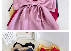 Detail of elegant satin bow hair clips in multiple colors with silky smooth texture