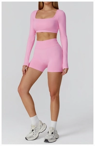 Front view of pink seamless high-waist yoga shorts and long sleeve crop top fitness set