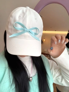 Detail of white baseball cap with light blue ribbon bow in balletcore style