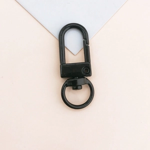 Detail of a matte black metal swivel lobster clasp for DIY keychains and bag charms