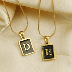 Collier chaîne serpent dorée avec pendentifs rectangulaires D et E sur de la soie