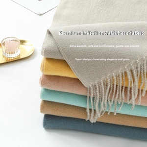 Close-up of soft cashmere-feel scarves showing layered colors and delicate fringe details