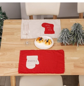 Detailed view of linen Christmas placemats with festive embroidery on a wooden dining table