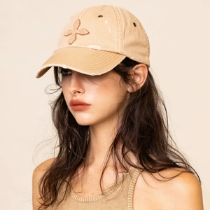 Detail of vintage khaki baseball cap with cross embroidery and distressed brim edge