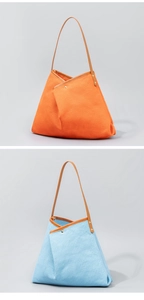 Detail of woven fabric tote bags in orange and light blue with leather handles and studs