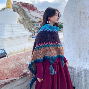 Close-up of bohemian knit poncho featuring colorful geometric patterns and fringe detail