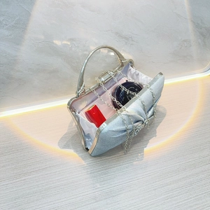 Detail view of silver evening bag interior with lipstick, phone, and chain strap