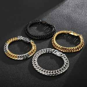 Flat lay of Cuban link bracelets in black, gold, and silver finishes with square clasps