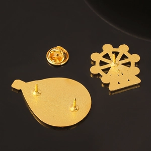 Detailed components of golden Ferris wheel enamel brooch with back pin and butterfly clasp