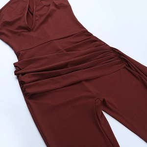 Detail showing the cutout neckline and ruched waist of a brick red slim jumpsuit