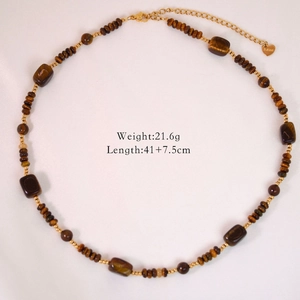 Flat lay of a tiger eye bead necklace with heart charm and size specs displayed