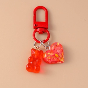 Detail of red bear and heart pendant with glitter sequins on a gold keychain hook