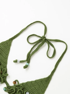 Détail de la maille au crochet verte avec des perles délicates et des lacets noués