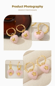 Detail of pink heart hoop earrings with gold star accent on a textured background