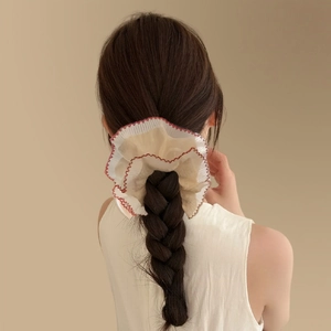 French style double-layer lace scrunchie in beige with red trim on a braided ponytail